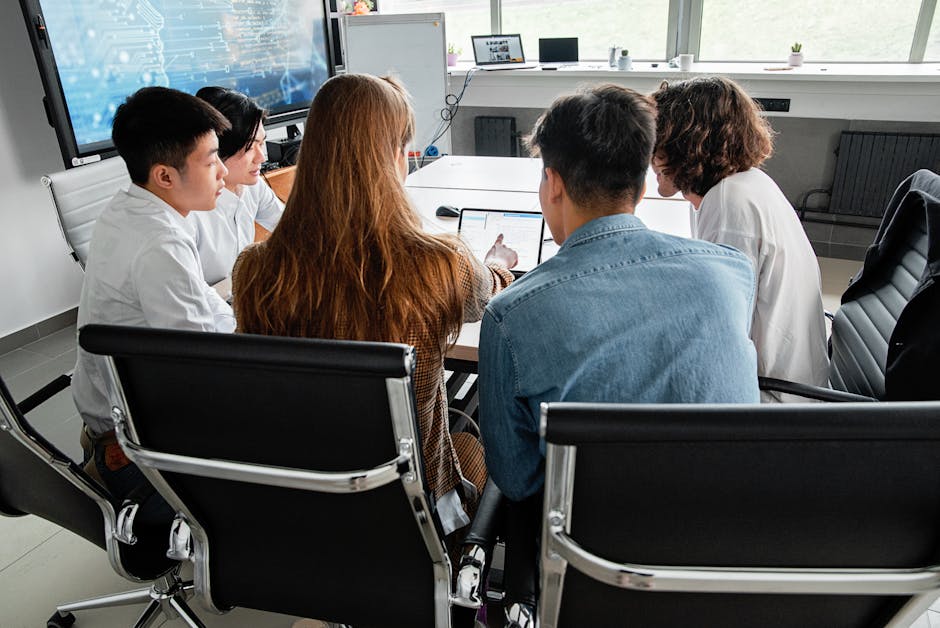 Team engaged in a collaborative meeting around a table in a modern office
